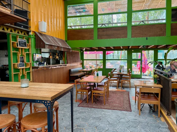 Converted warehouse-turned-restaurant with bright green and yellow accents and large windows overlooking park