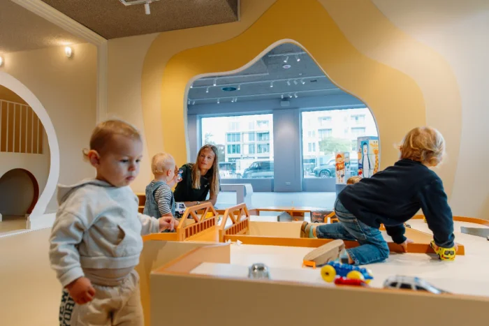 Kids and mom playing with toy vehicles on a table