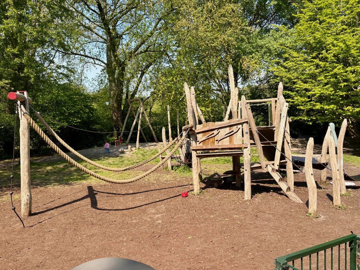 Natural wooden play structure with climbing ropes