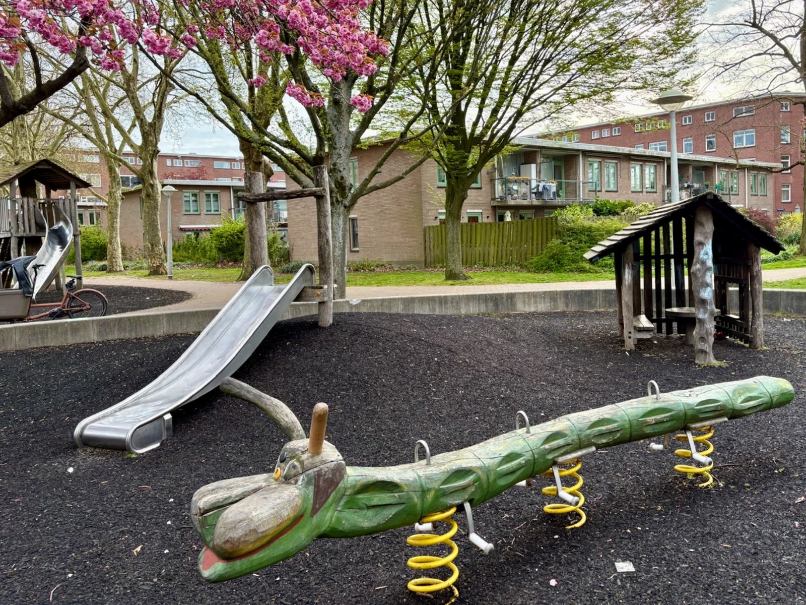 Green wooden caterpillar rocker and small slides and wooden play house