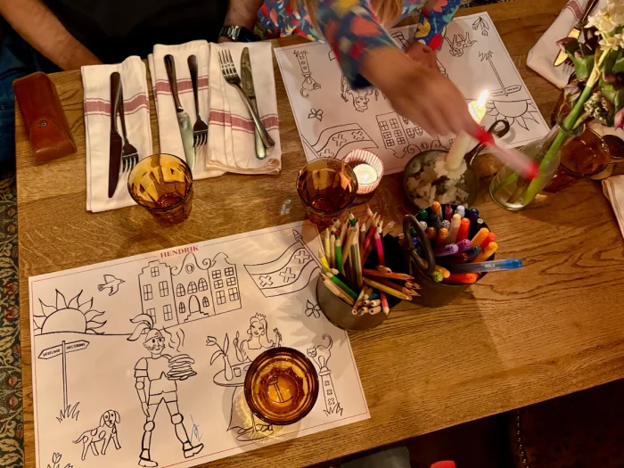 Coloring pages on a table with bucket of markers and colored pencils