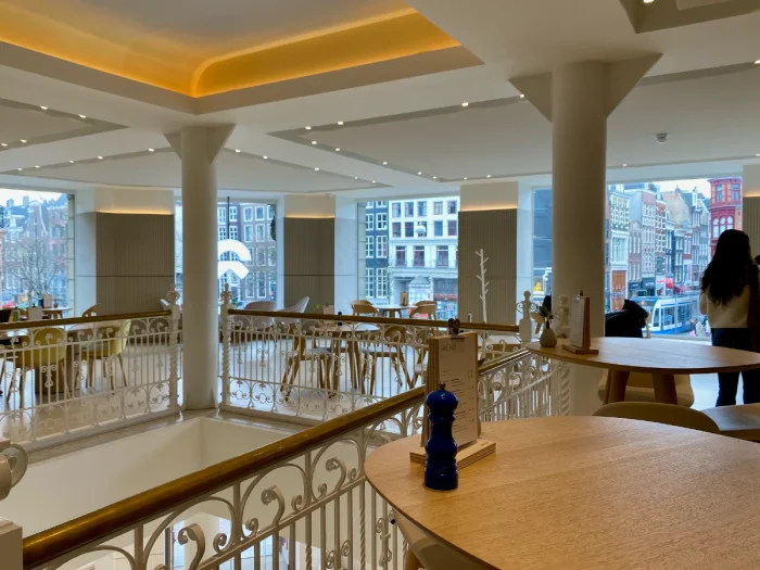 Bright and airy cafe space with large windows with view of Amsterdam and double height space connected to floor below