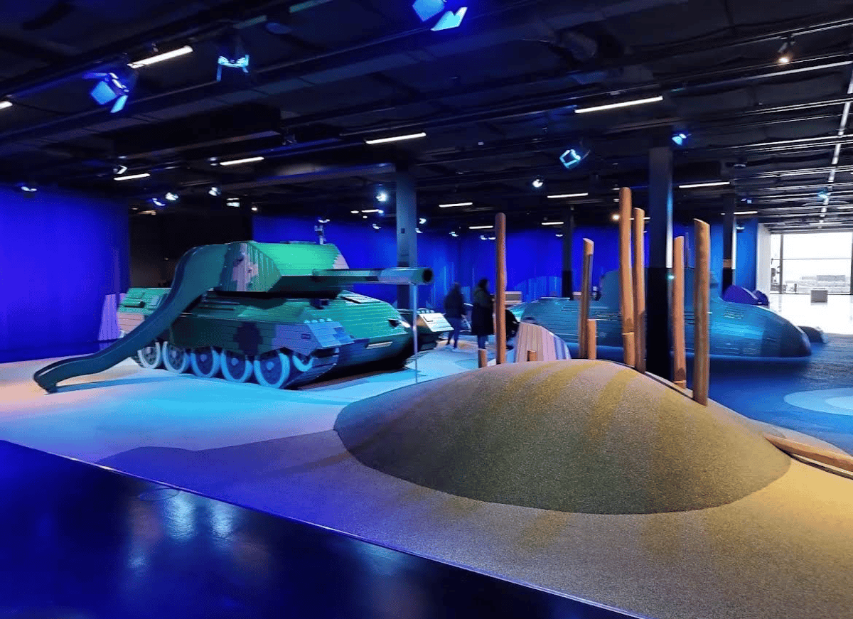 Military themed indoor playground with tank slide, climbing hill and play submarine