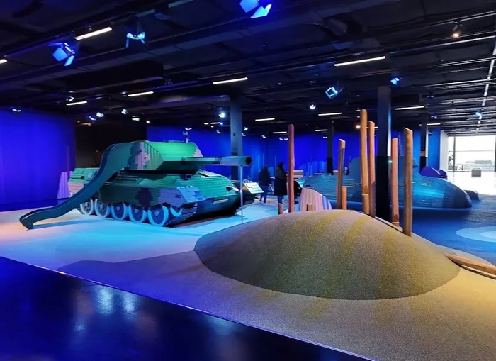 Military themed indoor playground with tank slide, climbing hill and play submarine