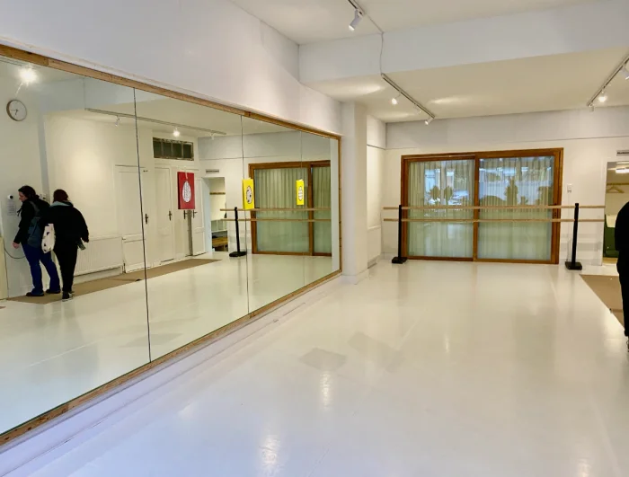Airy and bright dance studio with mirrored wall and ballet barre