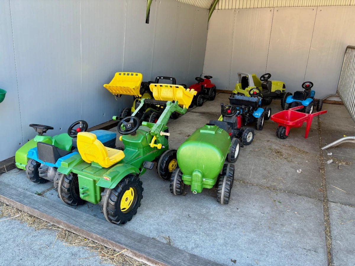 Shed with different play tractors and other farming equipment for kids