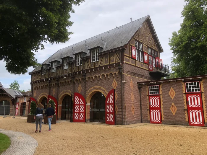 Brick horse stable building with red and white doors