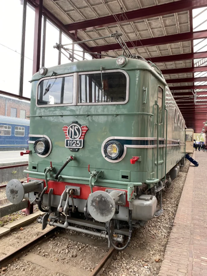 Front of a vintage pale green and red train on display in a railway museum