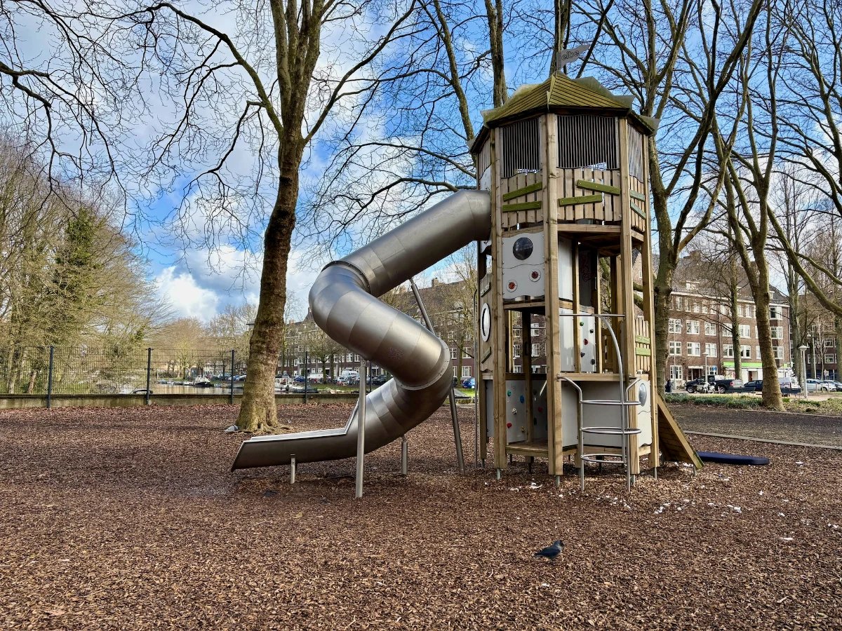 Tall wooden climbing structure with metal spiral slide