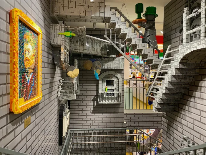 Full-size staircase built of legos that looks like Minecraft with grey bricks