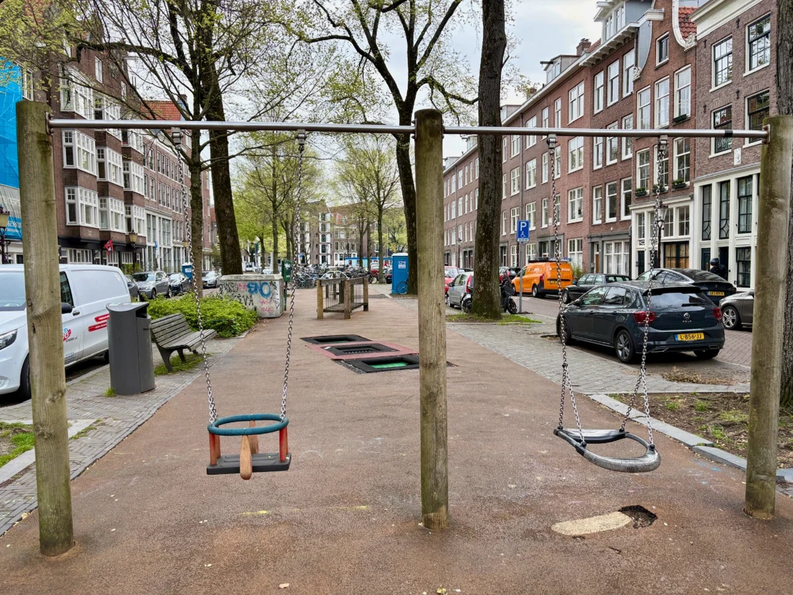 Simple wooden swing set with regular swing and baby swing on small residential playground
