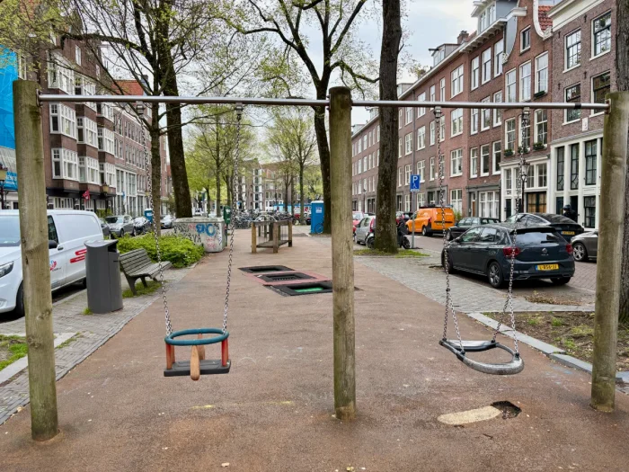 Simple wooden swing set with regular swing and baby swing on small residential playground
