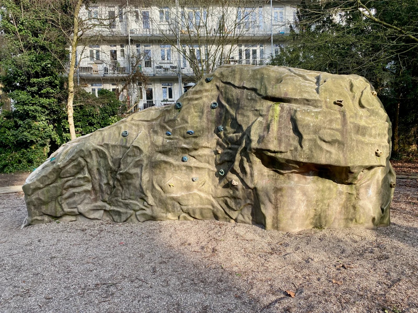 Outdoor natural-looking boulder with climbing holds