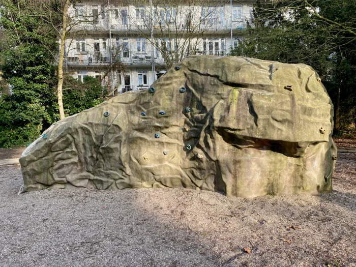Outdoor natural-looking boulder with climbing holds