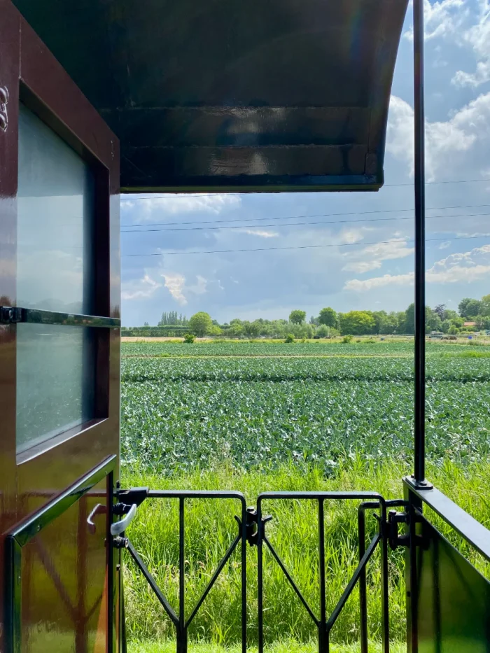 Farmland view from between two cars on a historic steam train