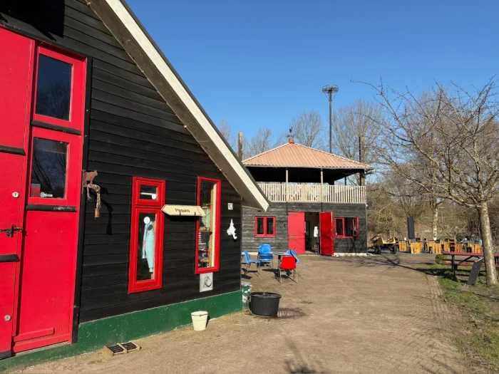 Barns at children's farm painted in a bright red and black with a few chairs outside