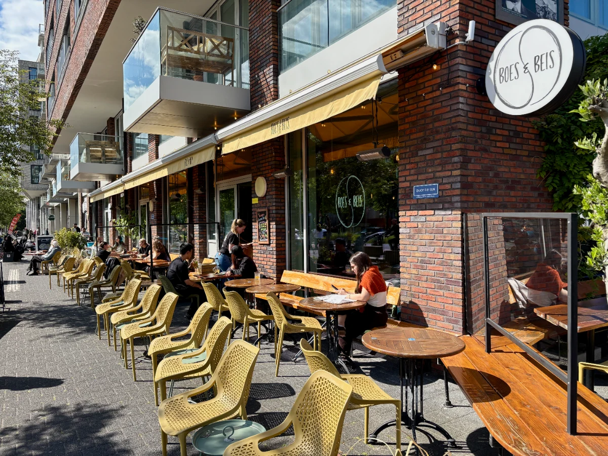 Sunny cafe terrace with yellow chairs and awning