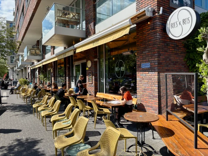Sunny cafe terrace with yellow chairs and awning