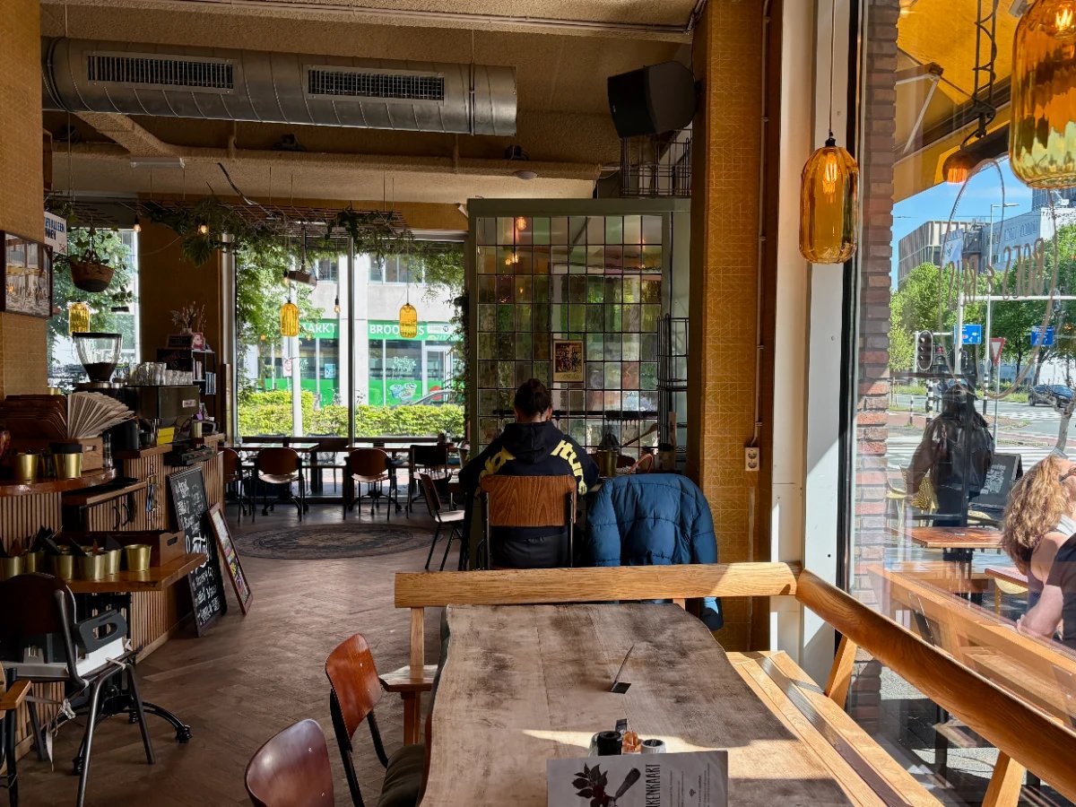 Cozy cafe interior with large windows, pendant lights, and stained glass