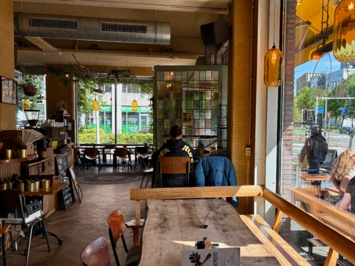 Cozy cafe interior with large windows, pendant lights, and stained glass