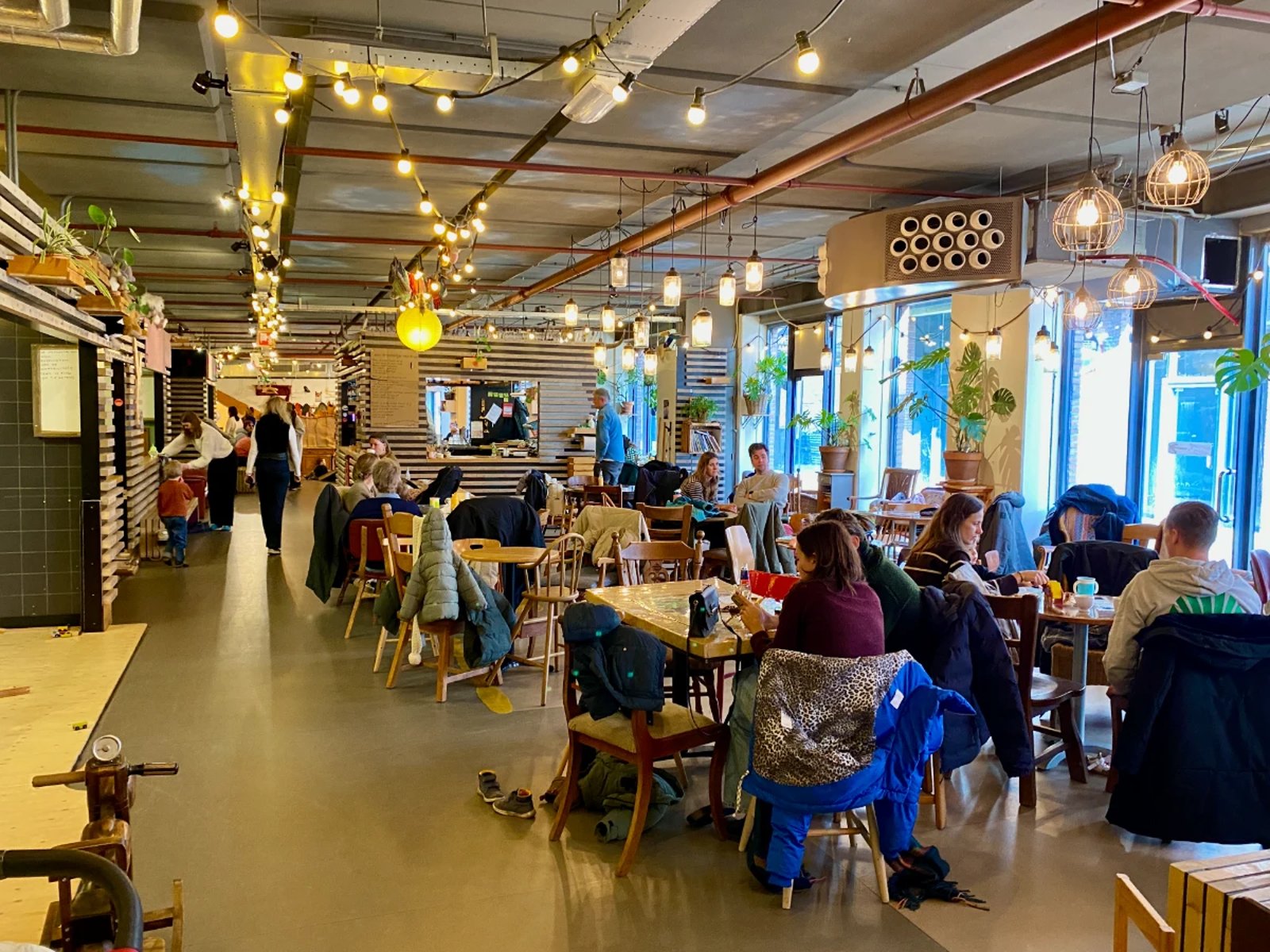 Cafe seating area at Houtebout with parents and children sitting at the tables