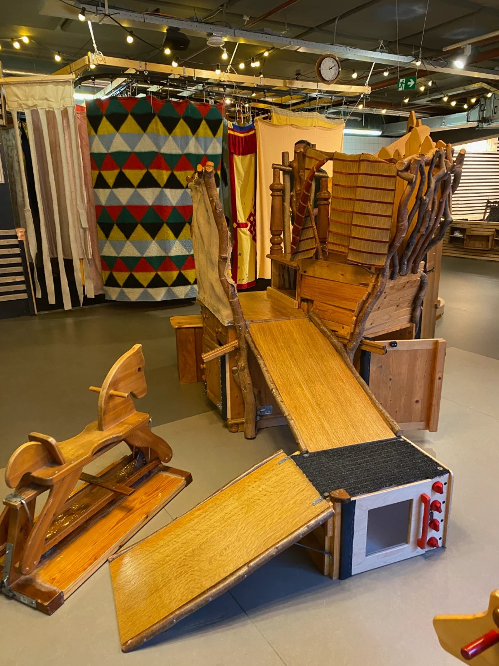 Handmade wooden play structure with slides and rocking horse