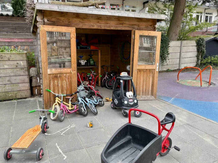 Wooden shed with children's bikes and vehicles