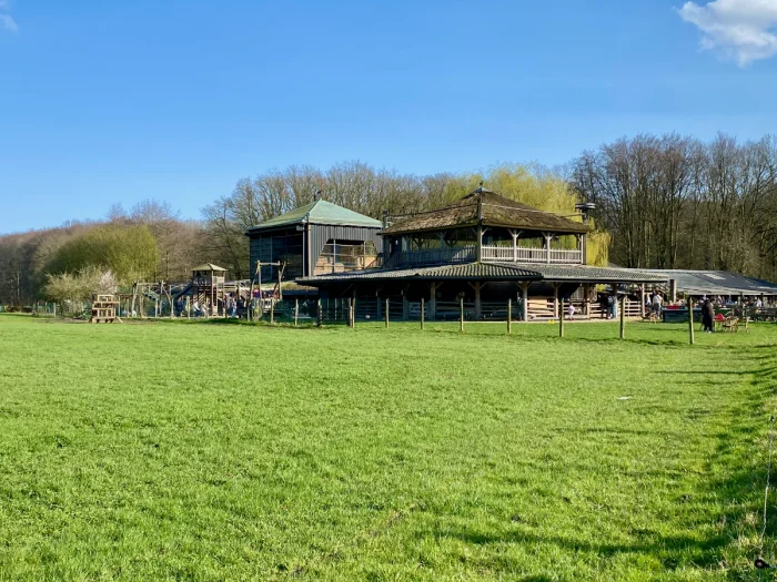 Wooden farm buildings set on grassy lawn