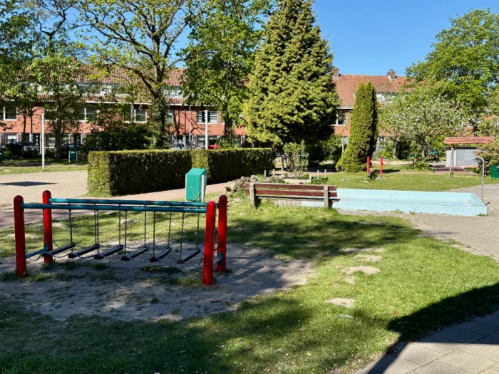 Balance bridge and empty paddling pool on sunny grassy playground