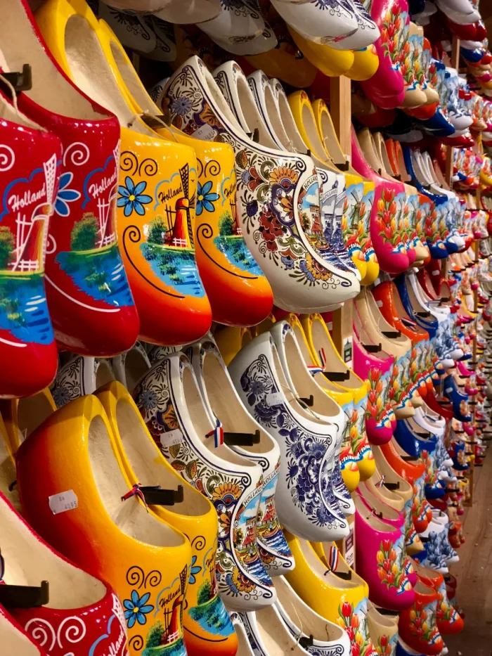 Colorful wooden clogs hanging on a wall painted in typical Dutch patterns