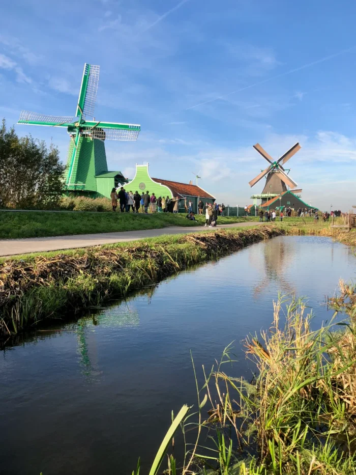 Bright green and wooden windmills along a canal