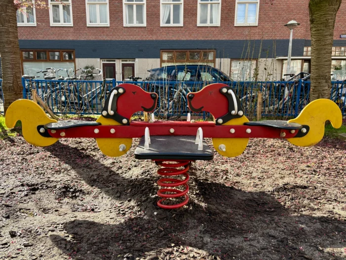 Red and yellow seesaw rocker that looks like two dogs