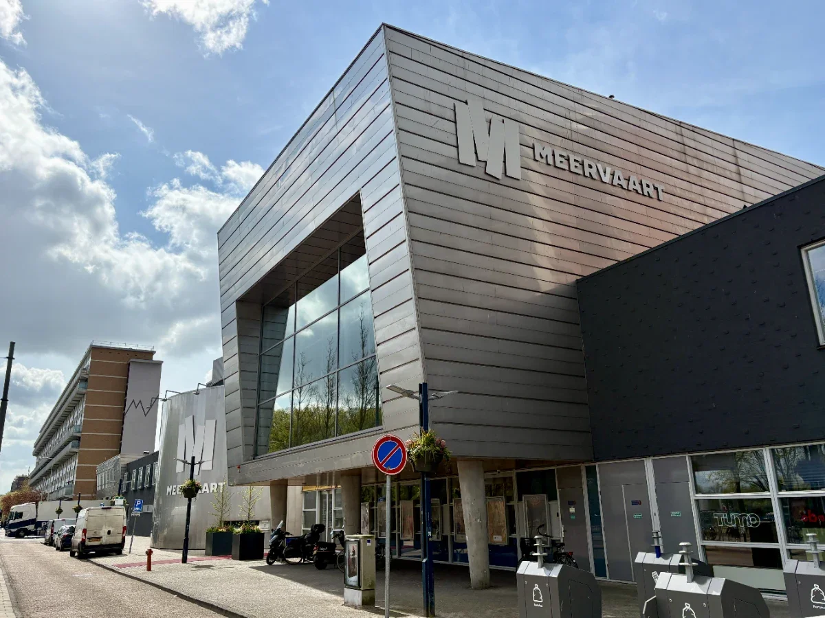 Modern performing arts building with metallic grey panels and large windows