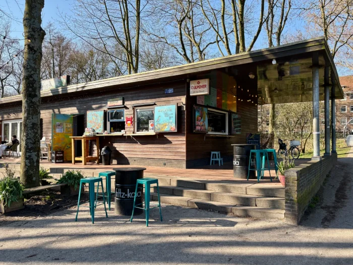 Exterior of Terrasmus cafe on a sunny day with colorful stools and signage outside