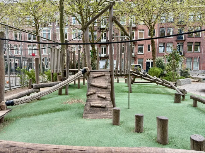 Wooden natural playground in residential urban area with climbing ramps, tight rope, balance course