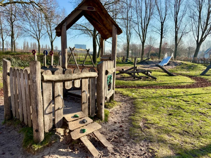 Playground with wooden play house on grassy lawn