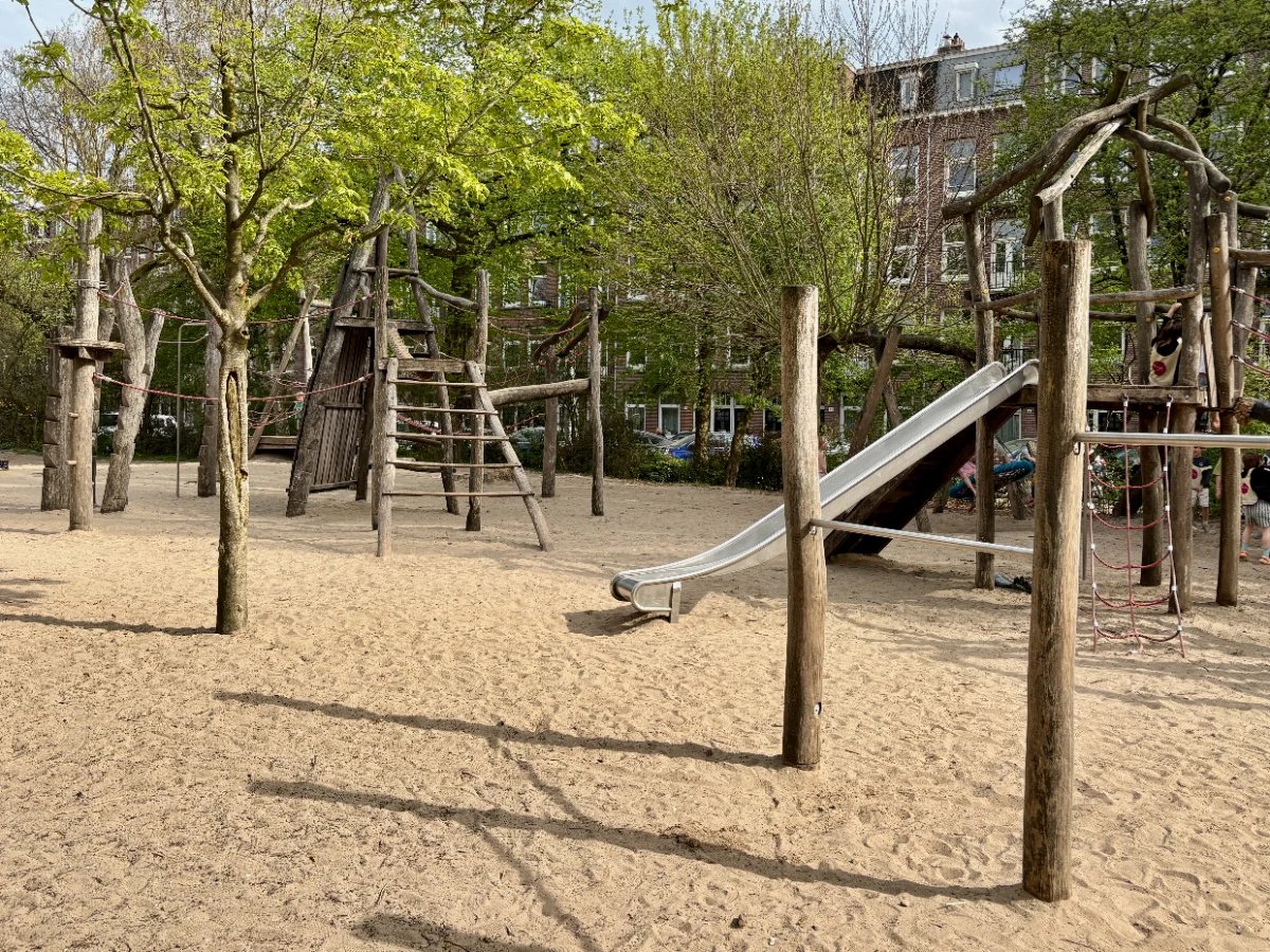 Wooden natural playground with slide, ladders and rope set on sand