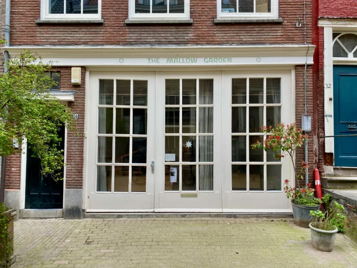 Storefront in historic Dutch building with white framed windows and brick