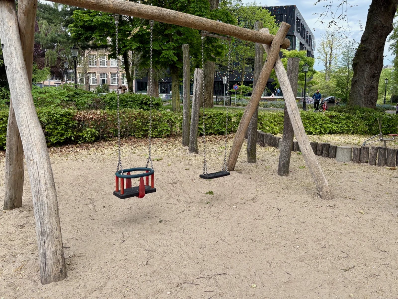 Rustic wooden swingset with baby swing and normal swing on sand