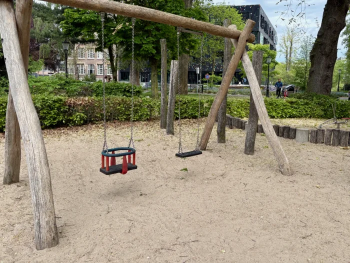 Rustic wooden swingset with baby swing and normal swing on sand