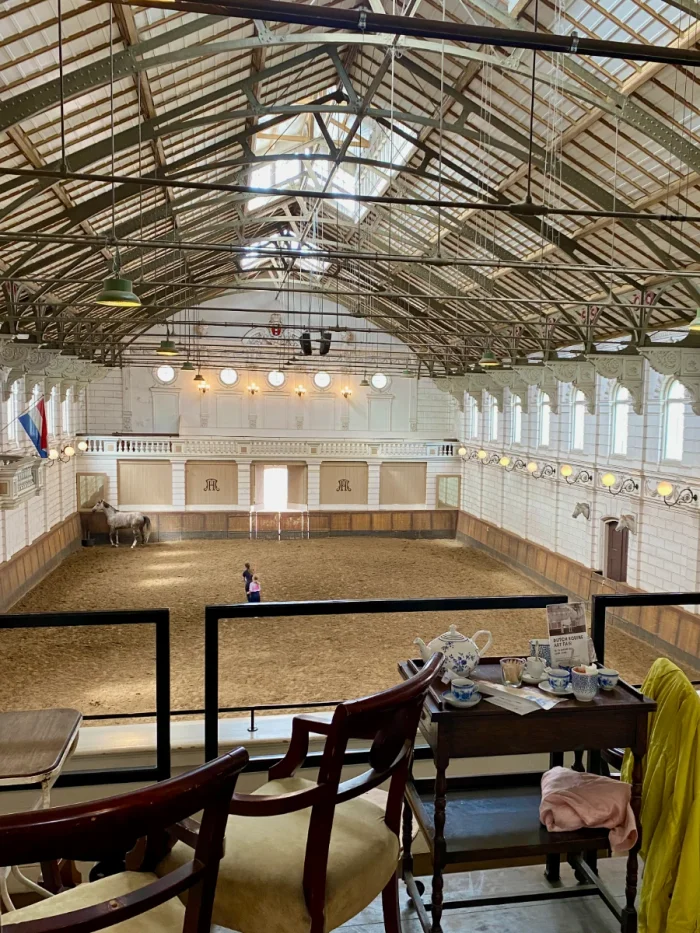 Table set for high tea on balcony overlooking historic horse riding hall