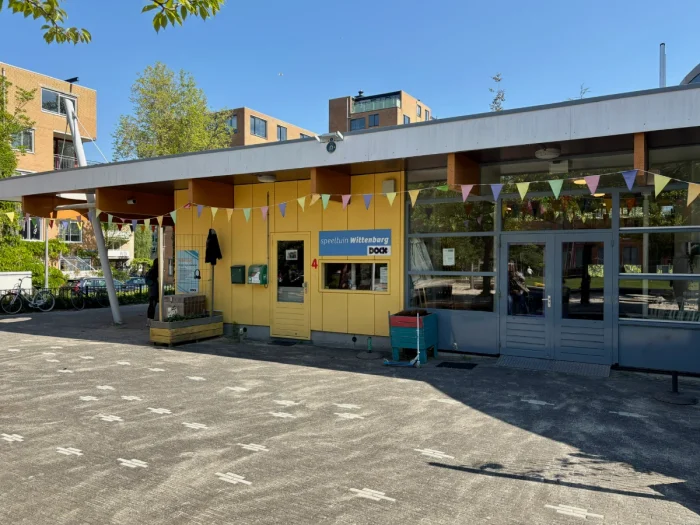 Yellow community center building with rainbow bunting flags