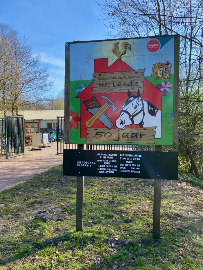 Entrance sign with "50 jaar" and a horse alongside a hammer and saw
