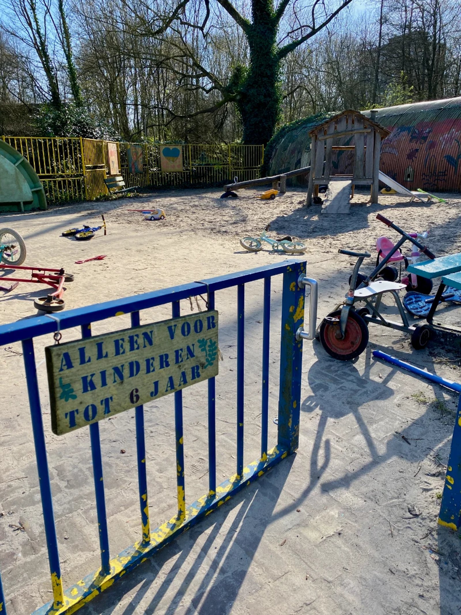 Playground with gate in the foreground and sign reading
