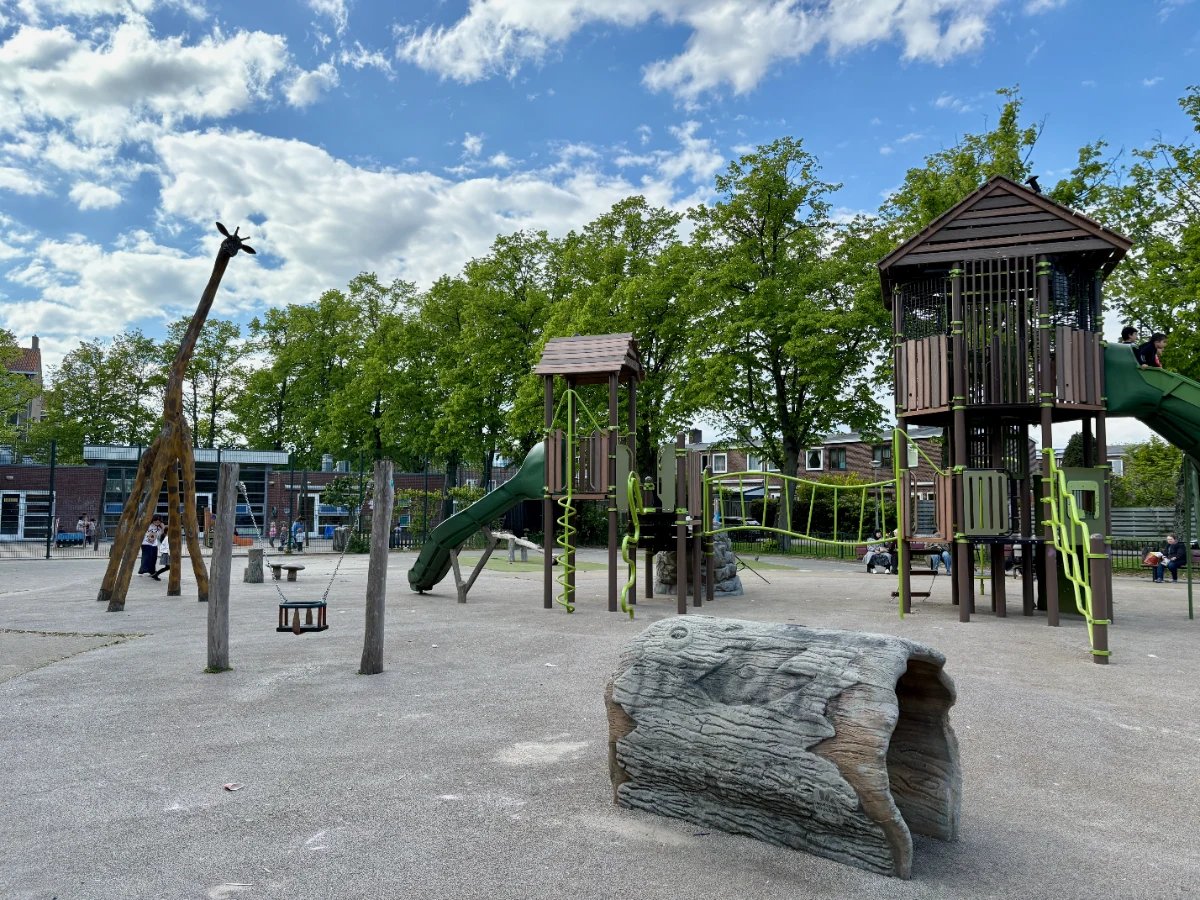 Large wooden climbing structure with two play houses alongside a wooden giraffe, tunnel, and baby swing