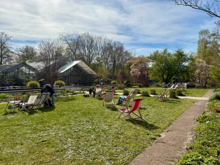 Greenhouses and lawn with people lounging in the sun in folding chairs