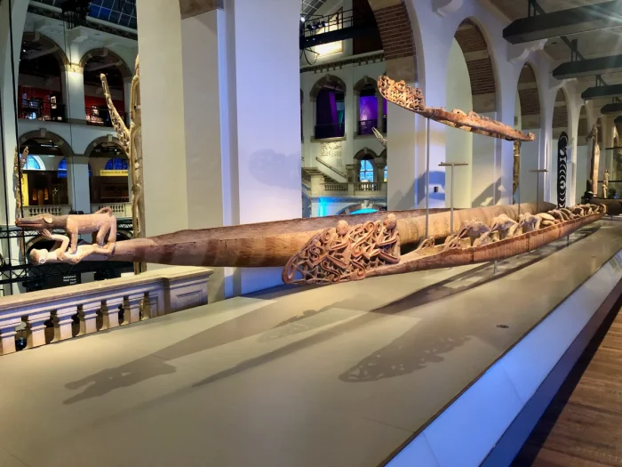 Ornately-carved wooden boats on display in a museum