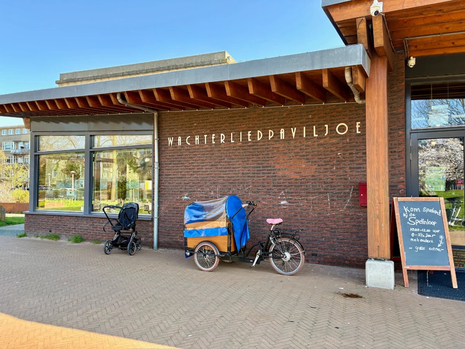 Brick building with windows and wooden beams and WACHTERLIEDPAVILJOEN written in metal letters on the side