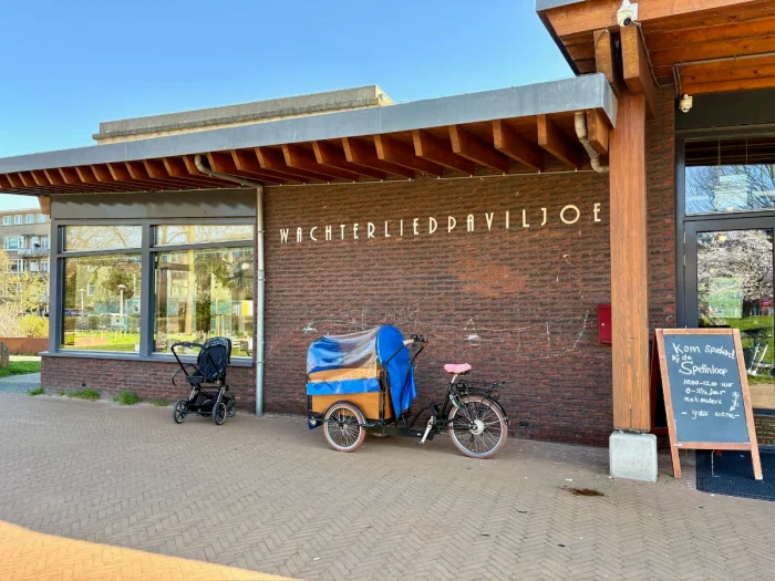 Brick building with windows and wooden beams and WACHTERLIEDPAVILJOEN written in metal letters on the side