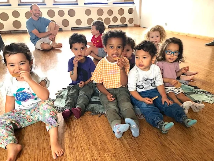 Group of kids sitting on the floor having a snack in a dance studio space